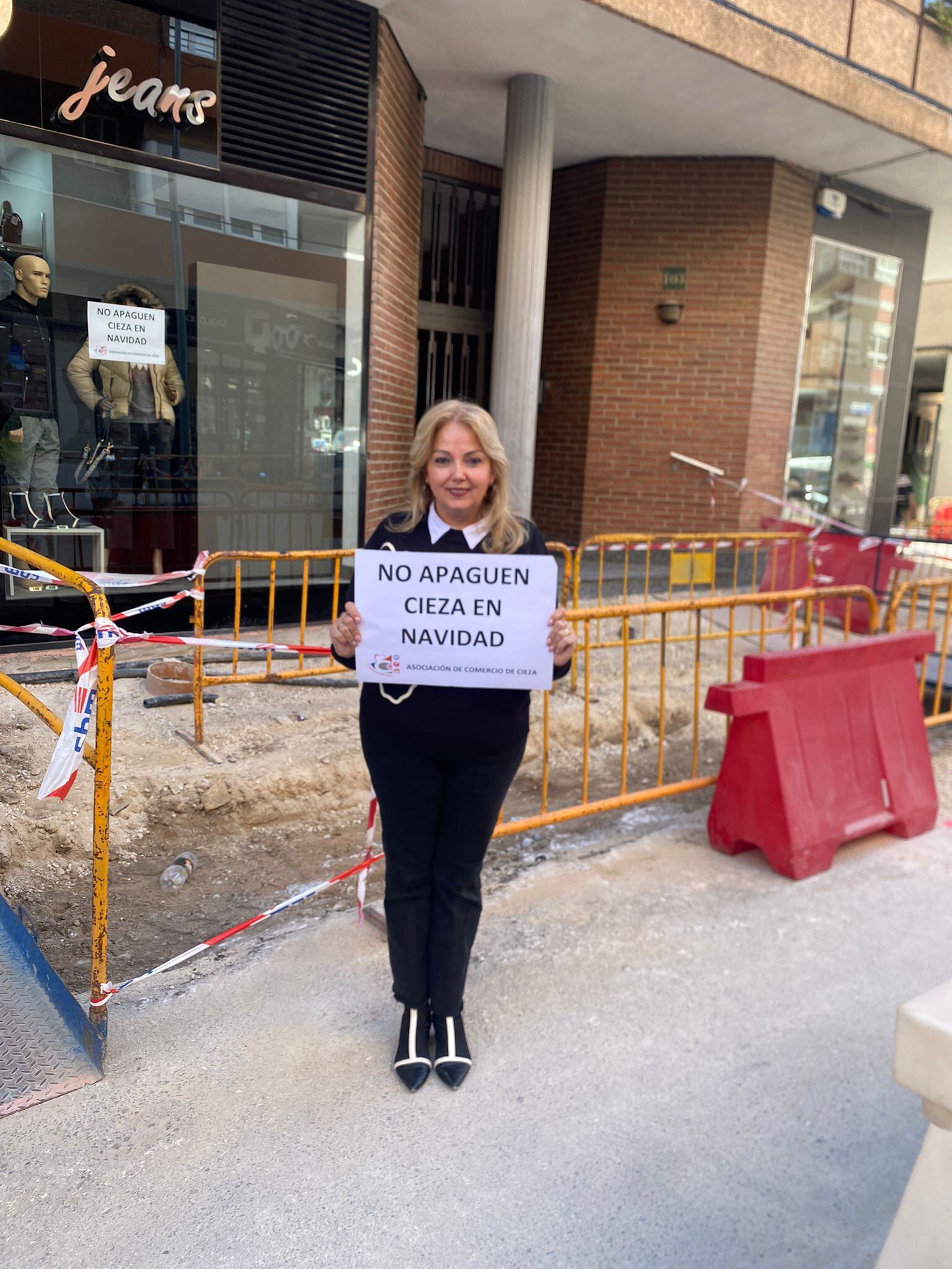 Mari Carmen Morcillo, presidenta de la Asociación Comercio de Cieza portando el cartel de la concentración