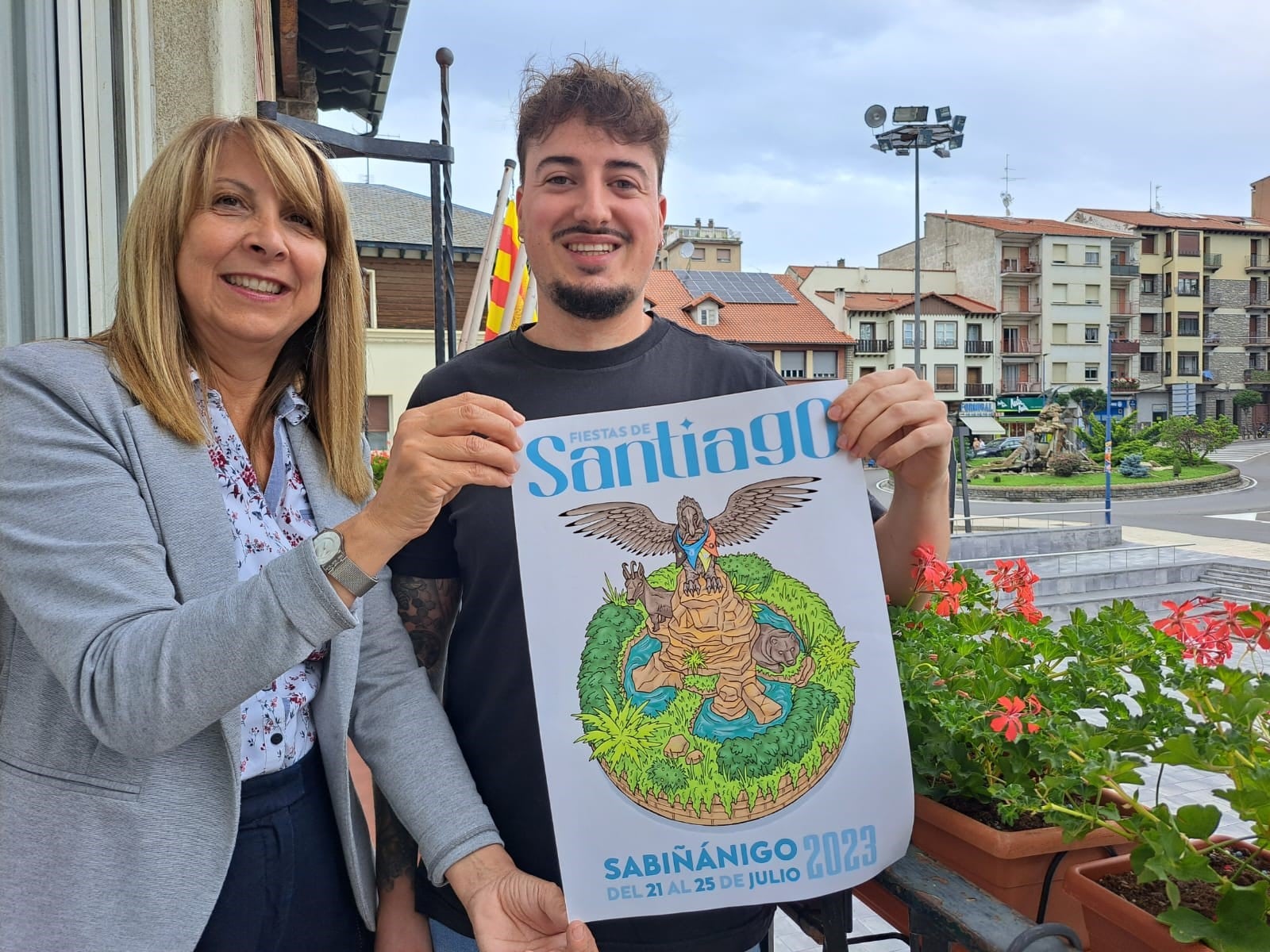 Un cartel que dibuja el quebrantahuesos de la rotonda con las pañoletas peñistas