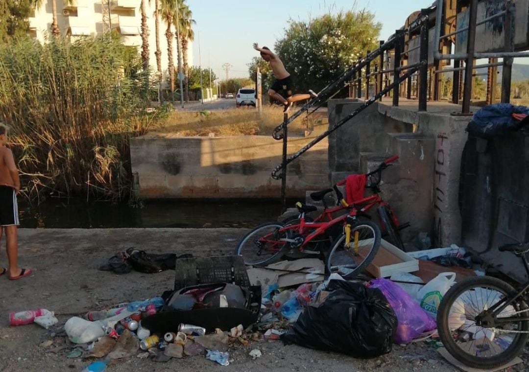 Jóven saltando desde el aliviadero del río Vaca entre Tavernes y Xeraco.