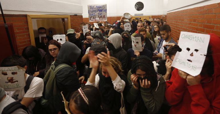 Unos 200 jóvenes, la mayoría con la cara oculta por caretas o pasamontañas, taponan desde dentro la puerta de la facultad de derecho de la Universidad Autónoma de Madrid