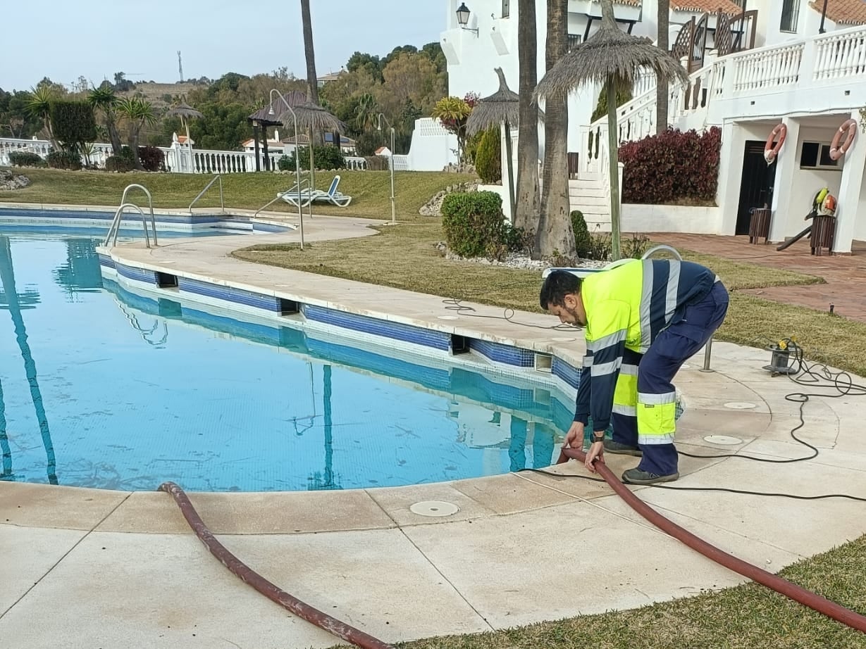 Operarios municipales en la piscina de la comunidad de vecinos