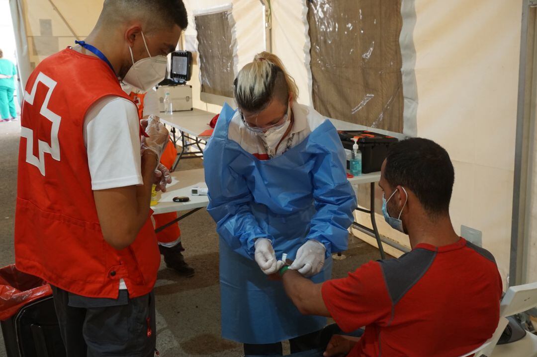 Una sanitaria atiende a una de las personas que ha llegado en la patera de Benidorm