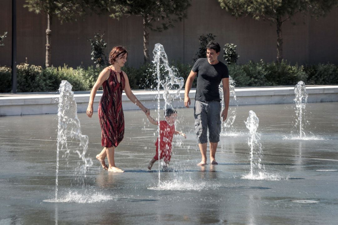 Varias personas se refrescan en una fuente del Parque Central de Valencia.