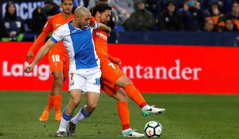 El delantero marroquí del Leganés, Nordin Amrabat (i), disputa el balón ante el centrocampista chileno del Málaga, Manuel Iturra (d), durante el partido disputado en el Estadio Municipal de Butarque, correspondiente a la jornada 27 de LaLiga.