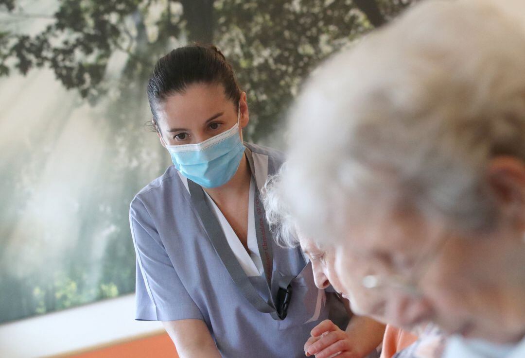 Una trabajadora cuidando de mayores.