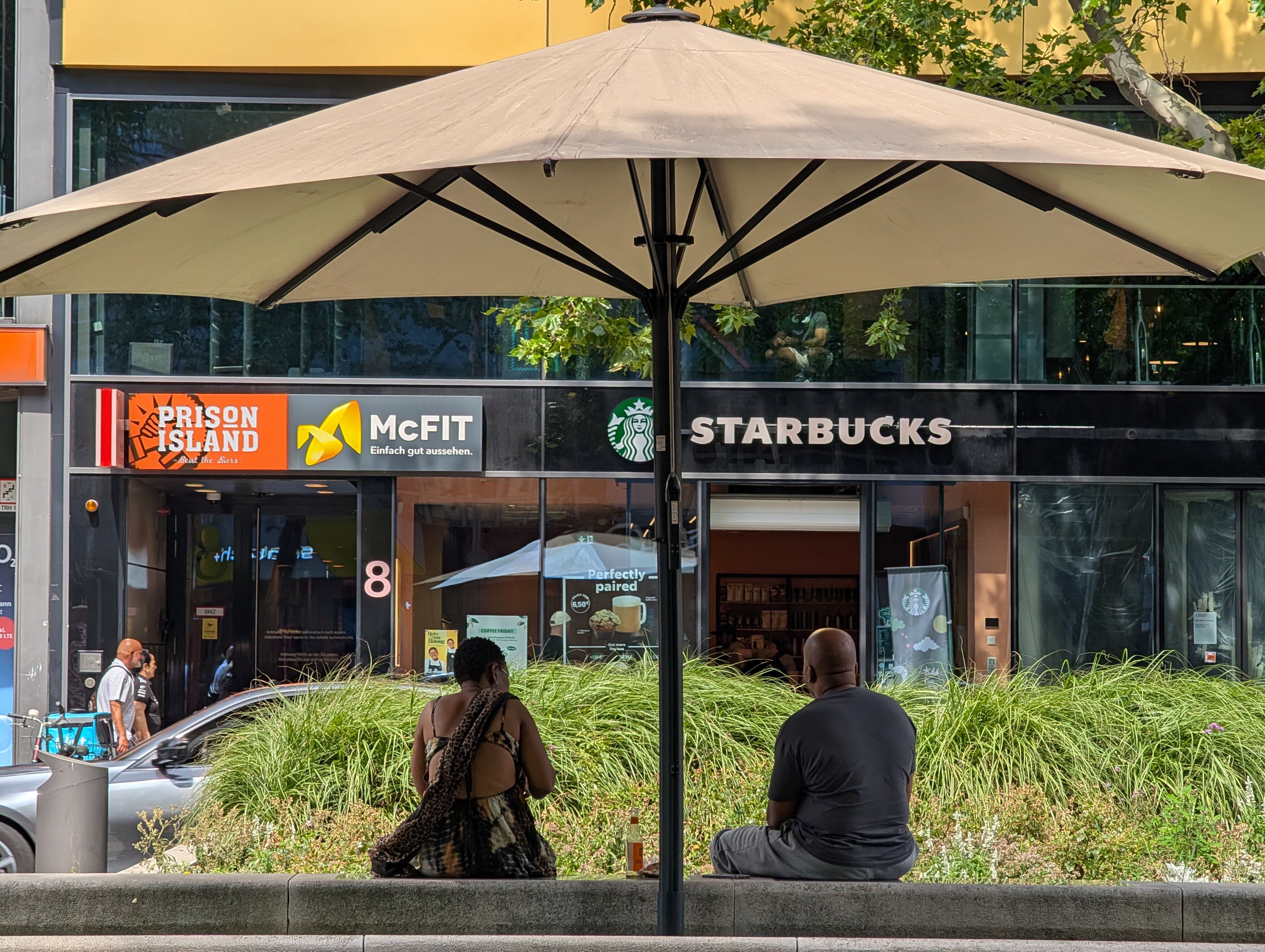 Una pareja se sienta frente a un Starbucks en Berlín, Alemania, el 20 de julio de 2025. Michael Nguyen/NurPhoto.