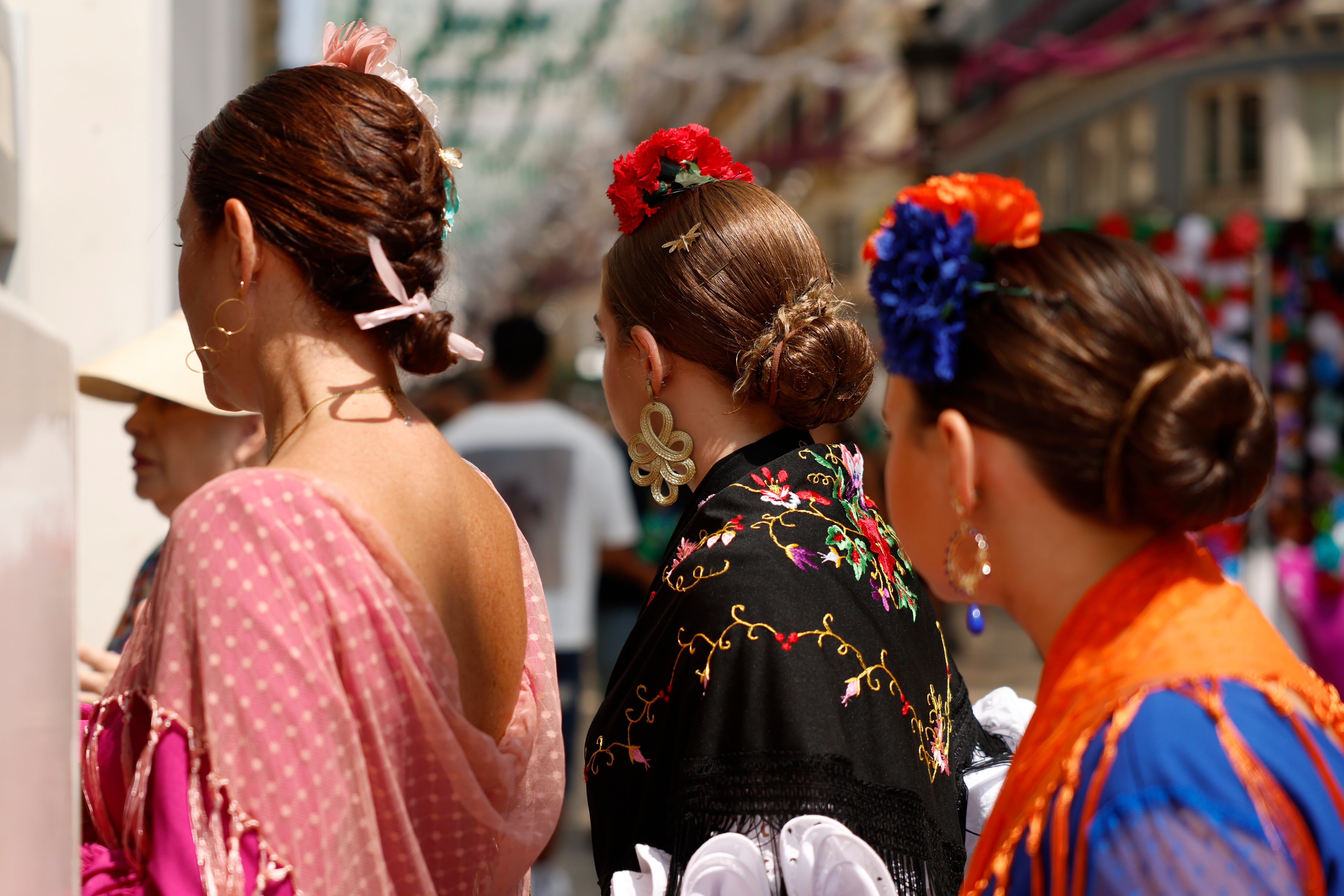 GRAFAND420. MÁLAGA, 21/08/2025.- Varias mujeres vestidas de faralaes pasean este jueves por la feria del centro de Málaga. EFE/Jorge Zapata
