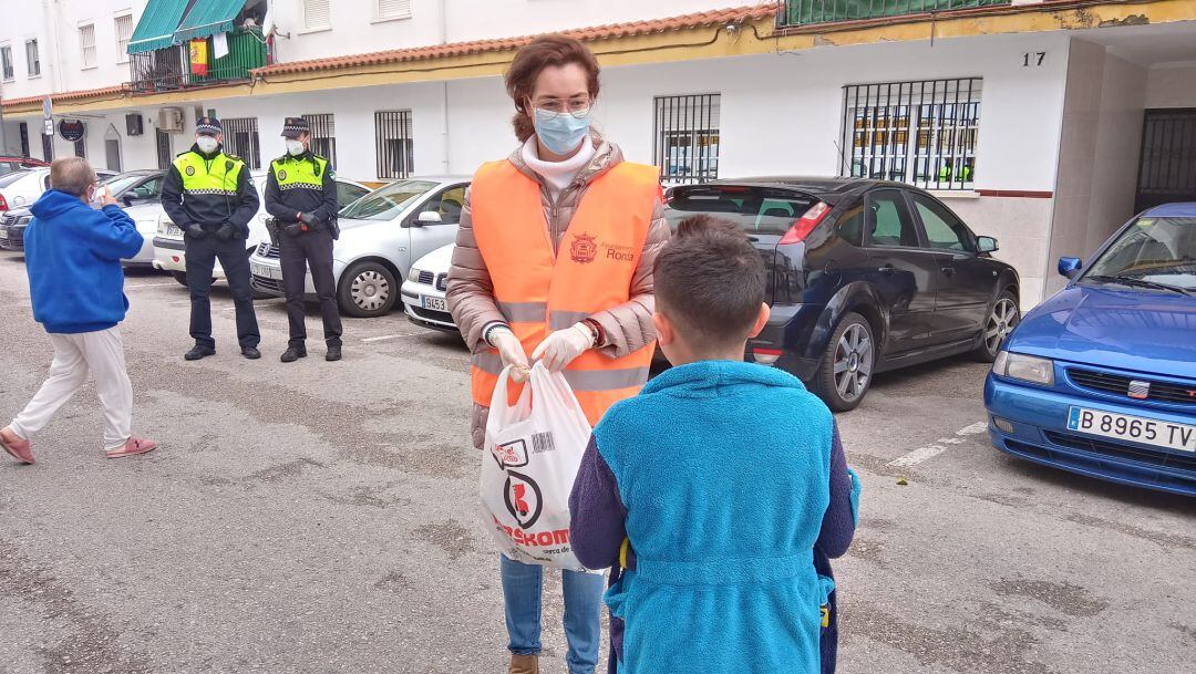 La concejal de Servicios Sociales, Cistina Durán, repartiendo golosinas a un joven ciudadano