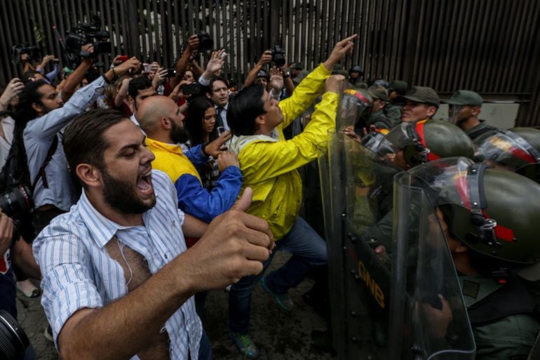 Soldados de la Guardia Nacional impiden el paso de un grupo de diputados que protestan en la sede del Tribunal Supremo de Justicia en Caracas, Venezuela.