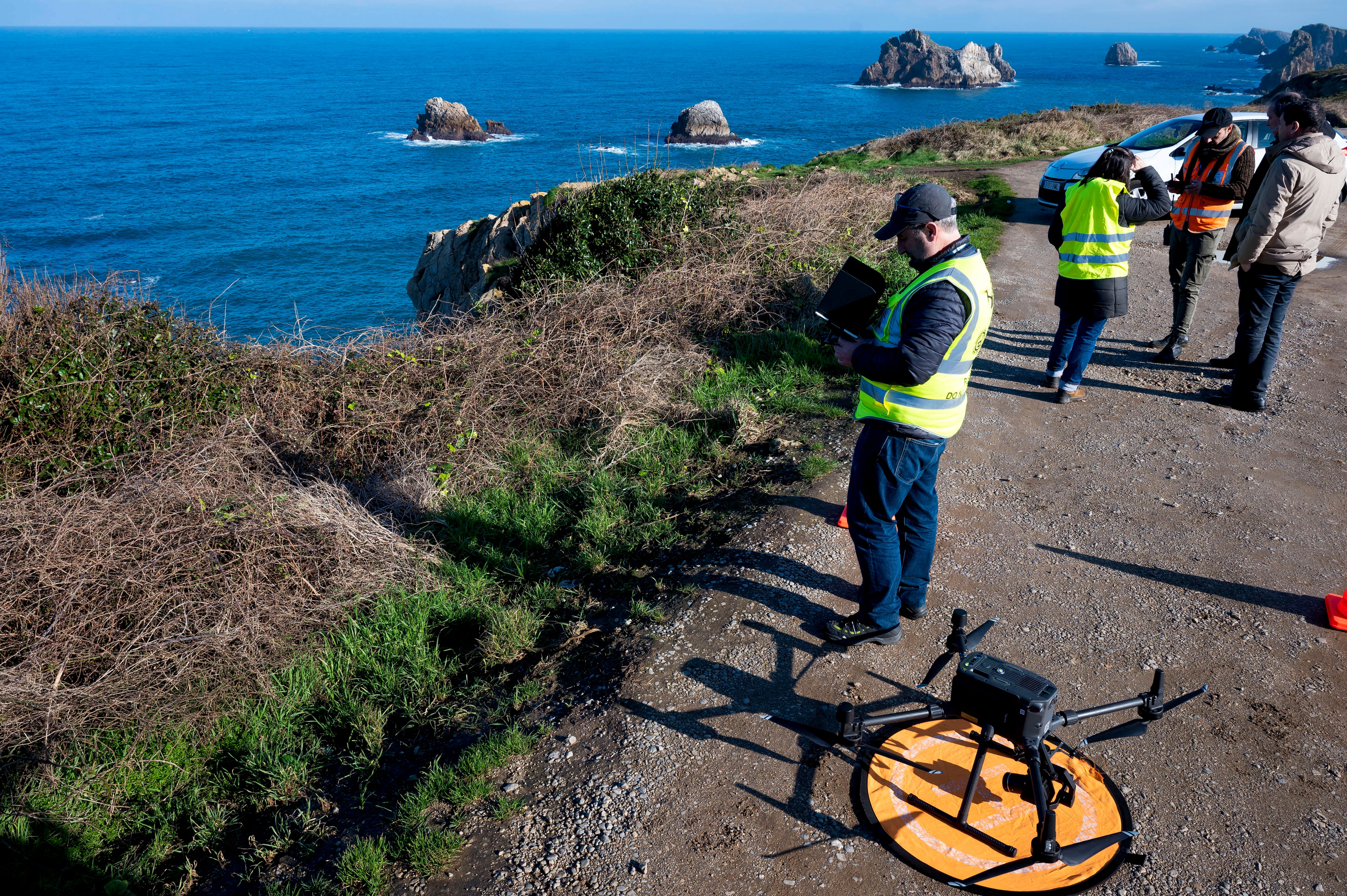 LIENCRES (CANTABRIA), 12/01/2024.- Pilotos de dron rastrean la playa de Somocuevas en la localidad de Liencres, en la costa cántabra, este viernes, para tratar de localizar pellets. La llegada de pellets de plástico procedentes del buque Toconao a las costas se sucederá previsiblemente durante las próximas semanas e incluso meses en varias oleadas, conforme se vayan degradando en el entorno marino los envases en los que están empaquetadas estas materias primas y según se comporten las mareas. EFE/Pedro Puente Hoyos
