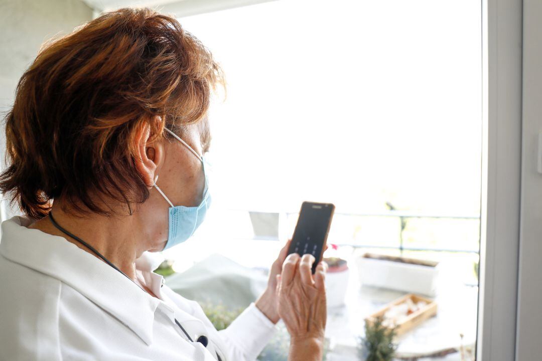 Archivo - Una mujer con discapacidad auditiva mira su teléfono durante la pandemia.