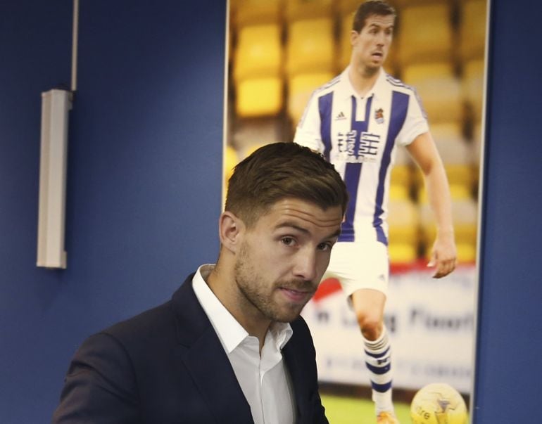 Iñigo Martínez entra en la sala de prensa de Anoeta con su foto detrás