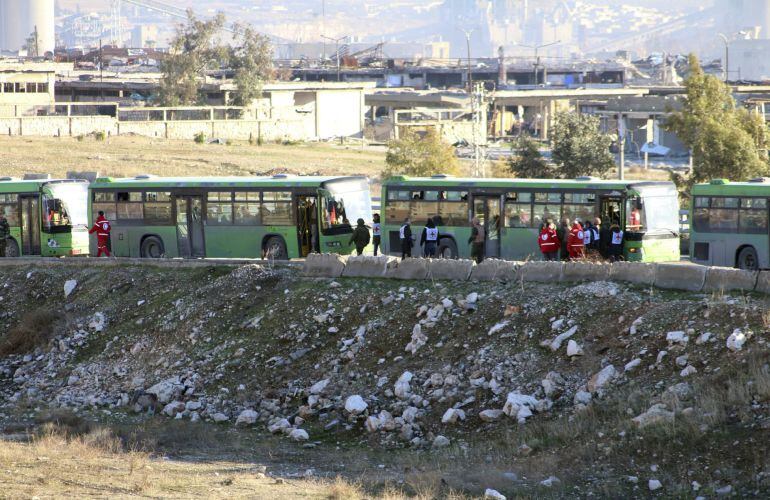 Autobuses del gobierno esperan a llevar a cabo la evacuación de los combatientes, sus familiares y civiles que se encuentran en los barrios rebeldes en Alepo.