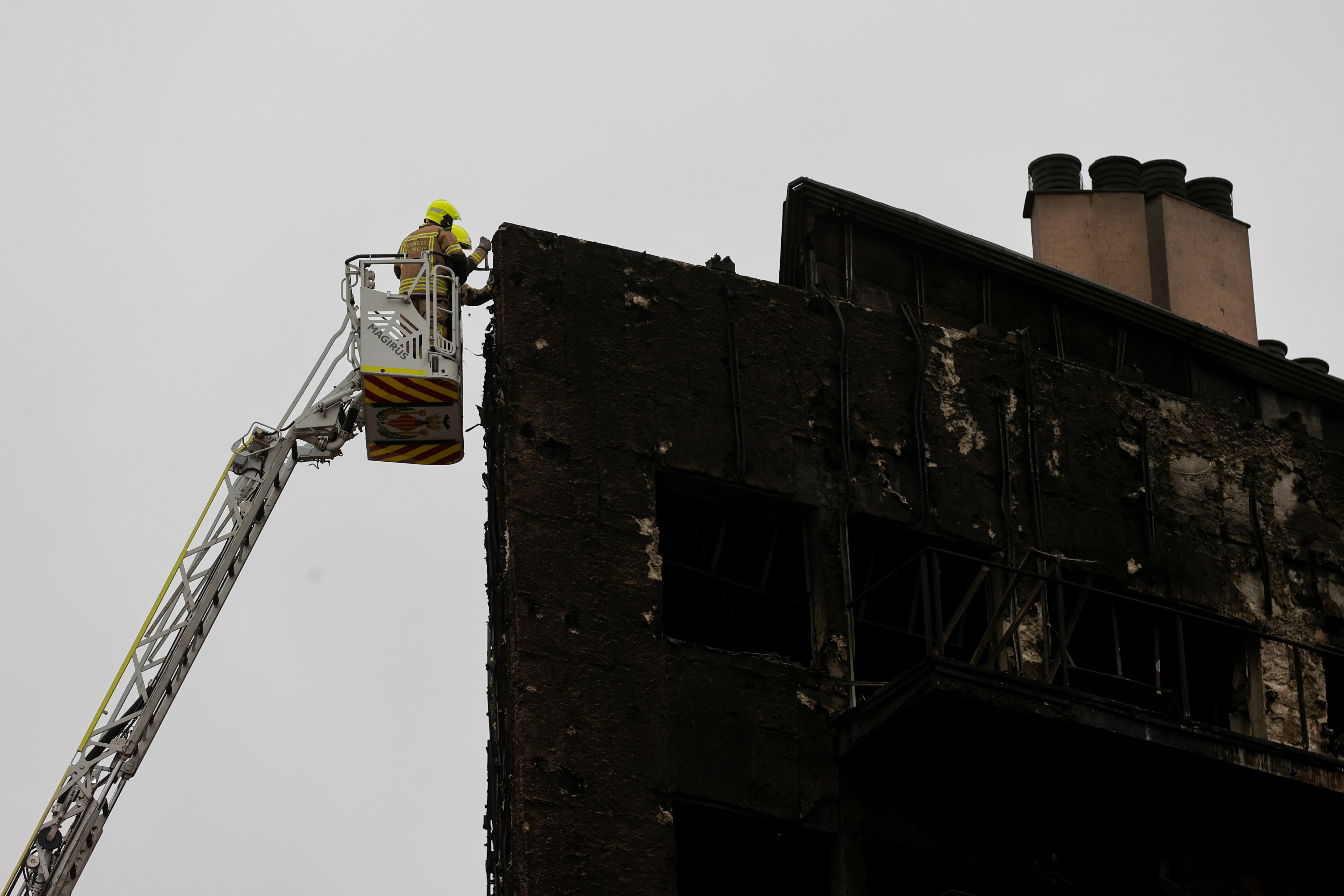 Unos bomberos trabajan en el edificio siniestrado en la zona del barrio valenciano de Campanar