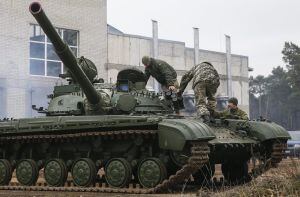 Varios trabajadores inspeccionan uno de los tanques que han sido enviados a reparar a una fábrica de vehículos blindados en Kiev, Ucrania.