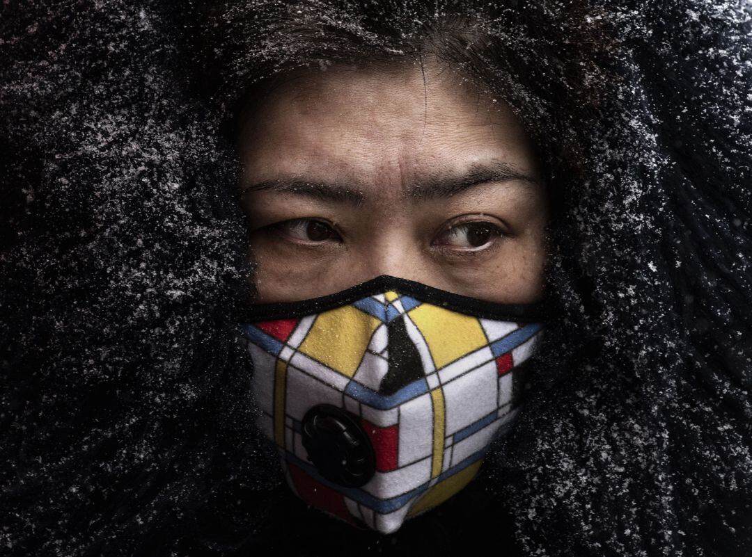 Una mujer lleva mascarilla en un mercado de Beijing, China