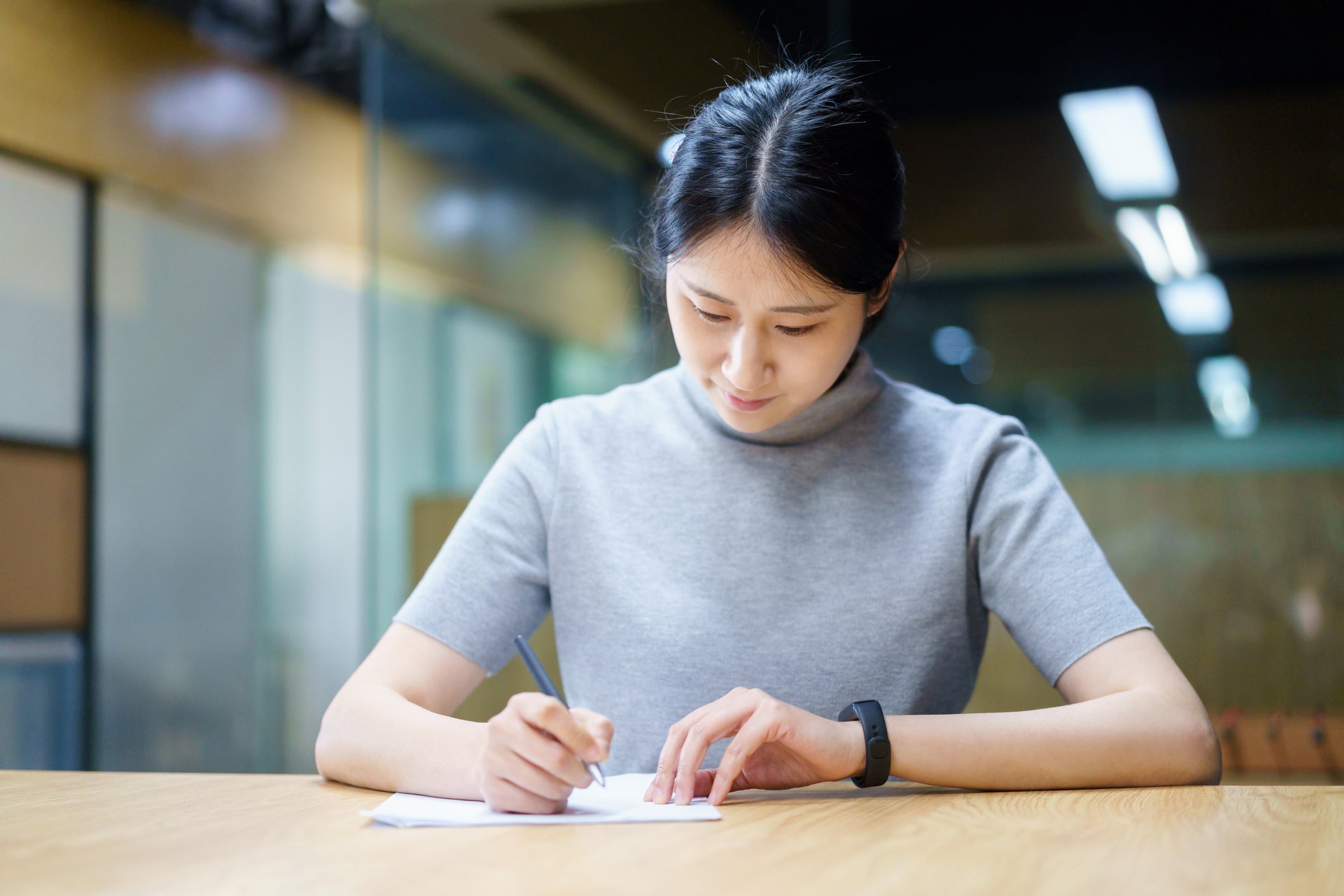 Imagen de recurso de una mujer asiática escribiendo a mano.