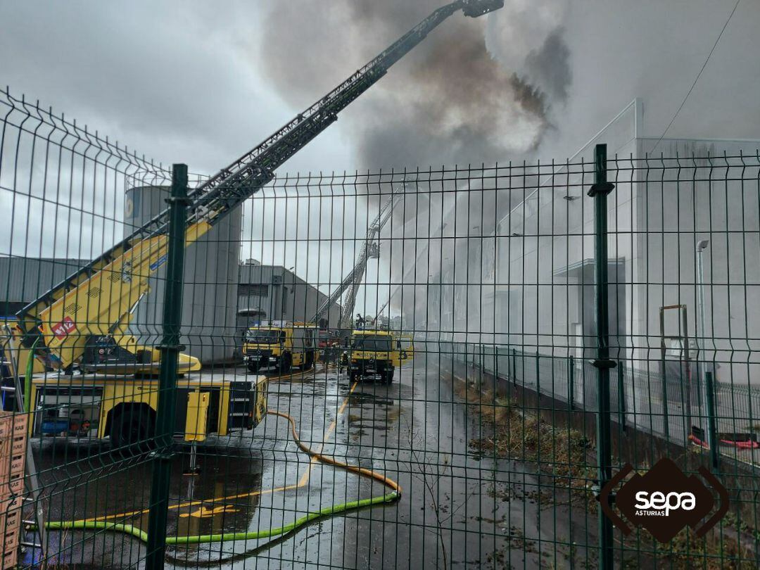 Los equipos de extinción de incendios, procedentes de varios parques, atacan el fuego declarado en las naves del polígono industrial de Silvota