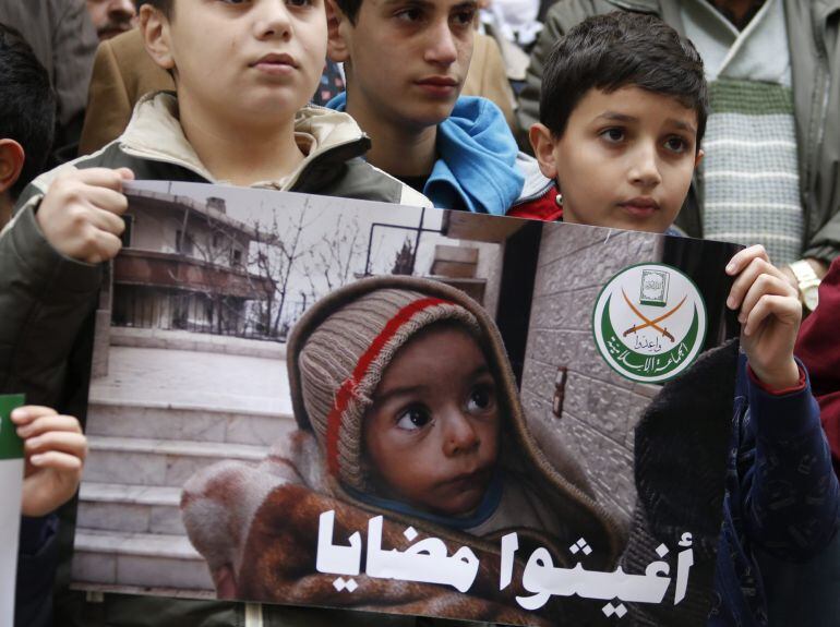 Seguidores del grupo islámico Jemaah Islamiyah muestran una imagen de un niño, supuestamente del pueblo sirio de Madaya, durante una protesta frente a la sede de la Cruz Roja Internacional en Beirut.