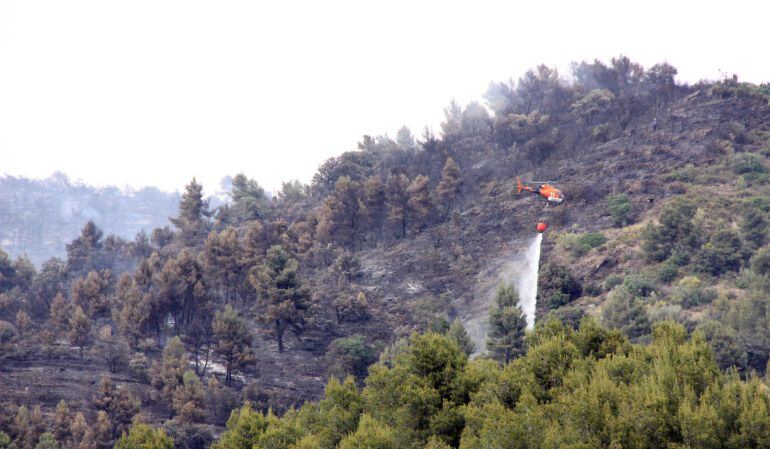 Un helicòpter remullant la zona afectada.
