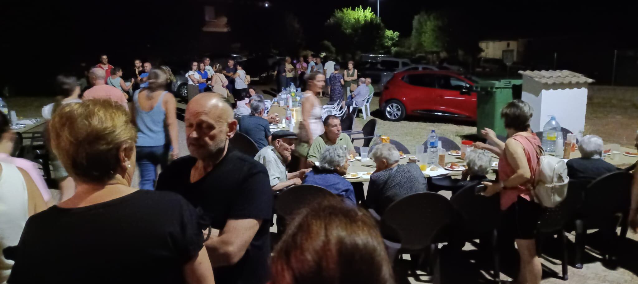 Varias personas cenan en la puerta del auditorio municipal de Tábara