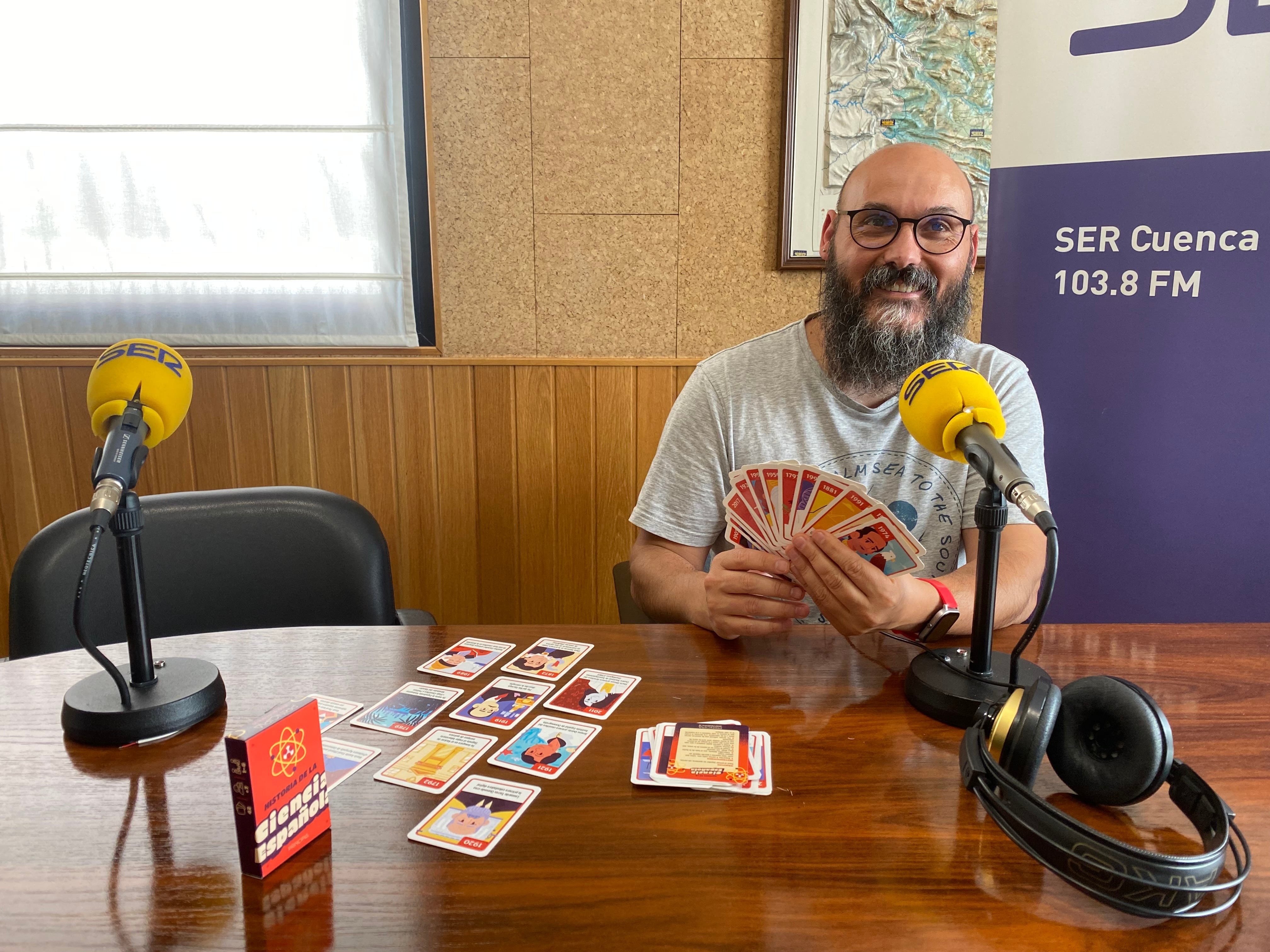 Enrique Royuela en SER Cuenca con la baraja del juego &#039;Historia de la ciencia española&#039;.