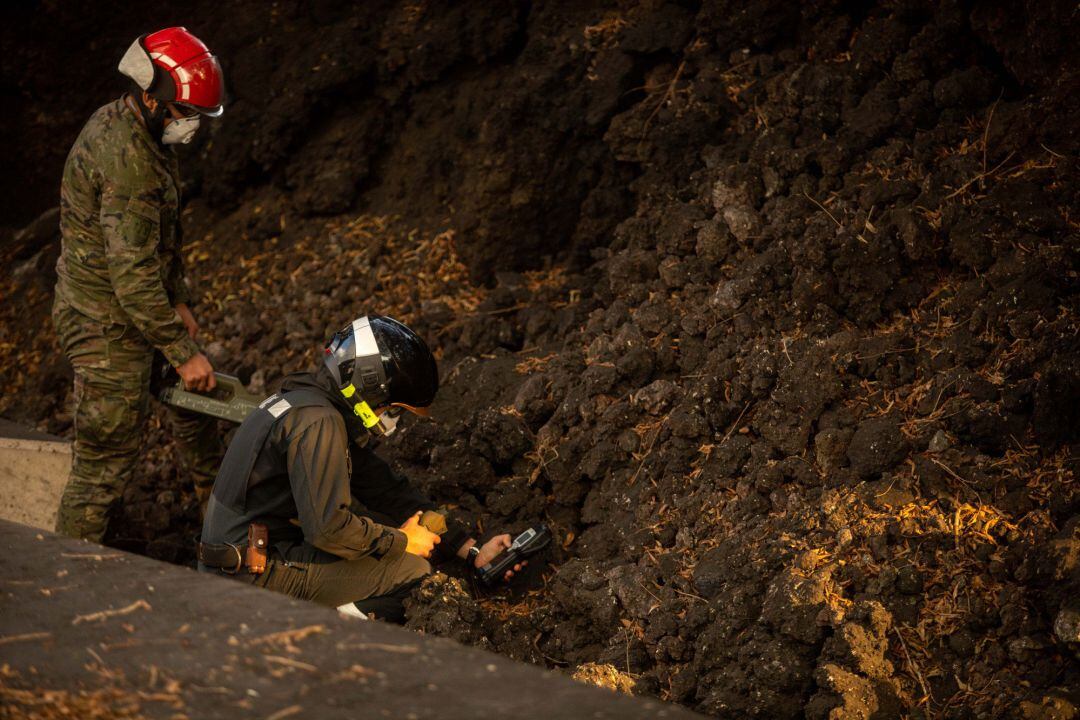 Varios operarios observan la lava del volcán de cumbre vieja desde la Montaña del municipio de La Laguna