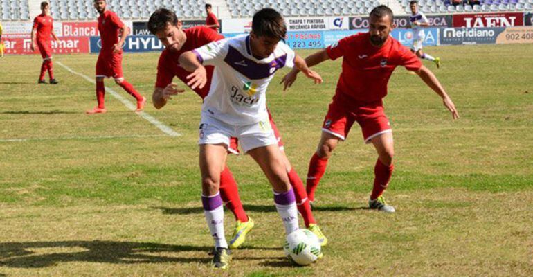 Un jugador del Real Jaén pelea por el balón frente a dos rivales del Lorca.