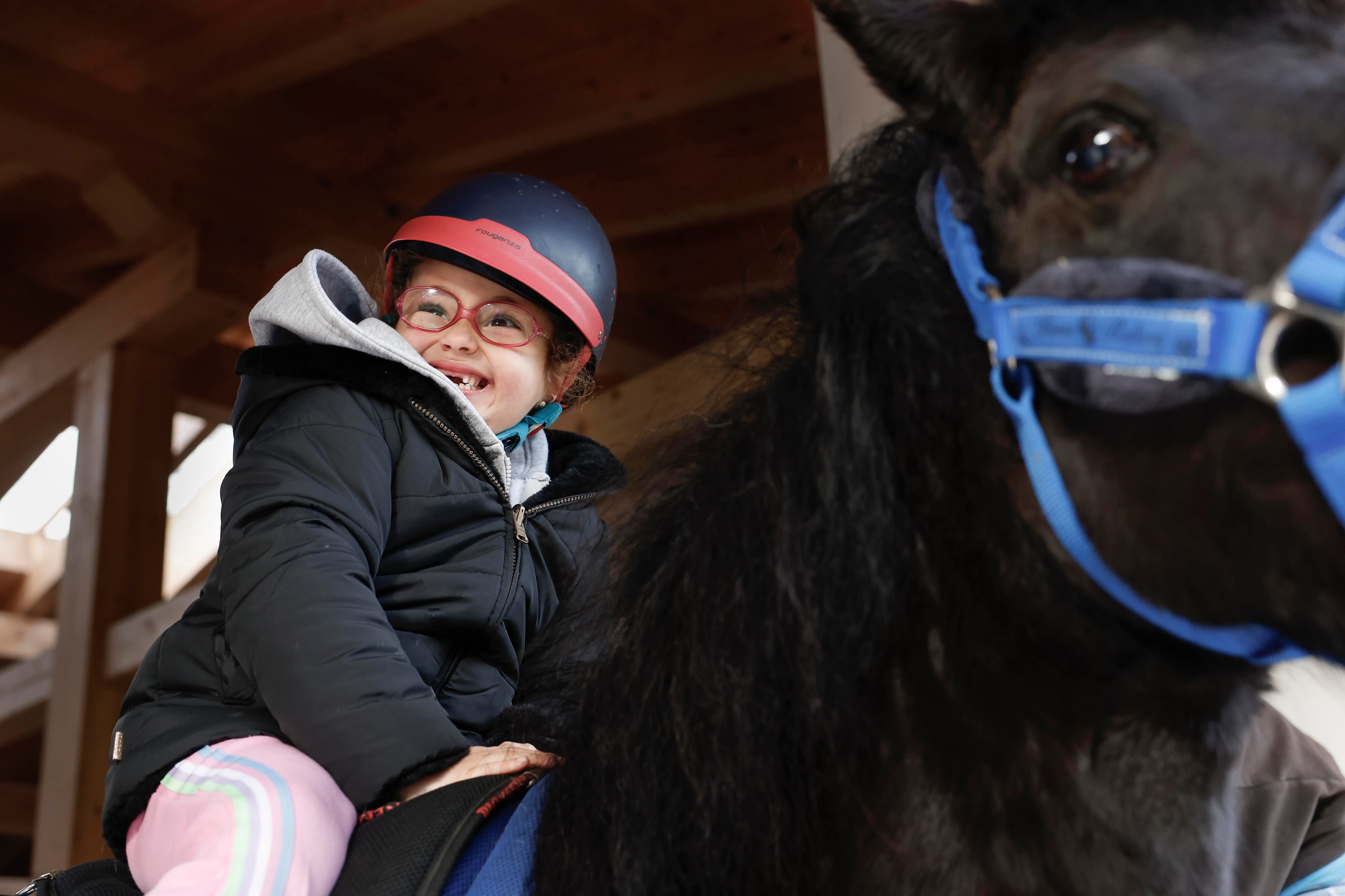 Una niña afectadas por el síndrome CTNNB1, en una terapia con caballos para paliar los efectos de esta enfermedad rara. EFE/Miguel Toña