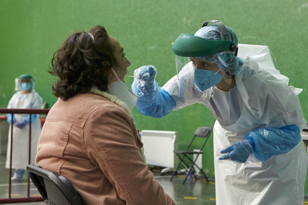 Un sanitario toma muestras a una mujer para realizar una PCR