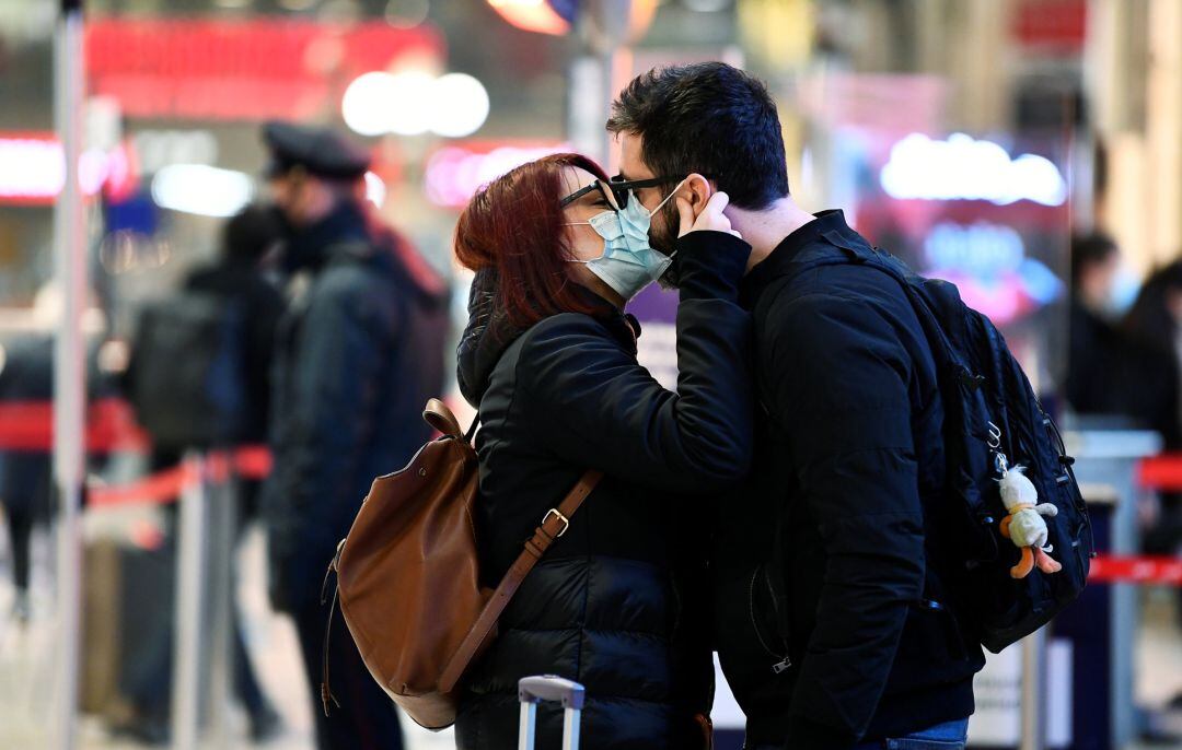 Pareja besándose con mascarilla