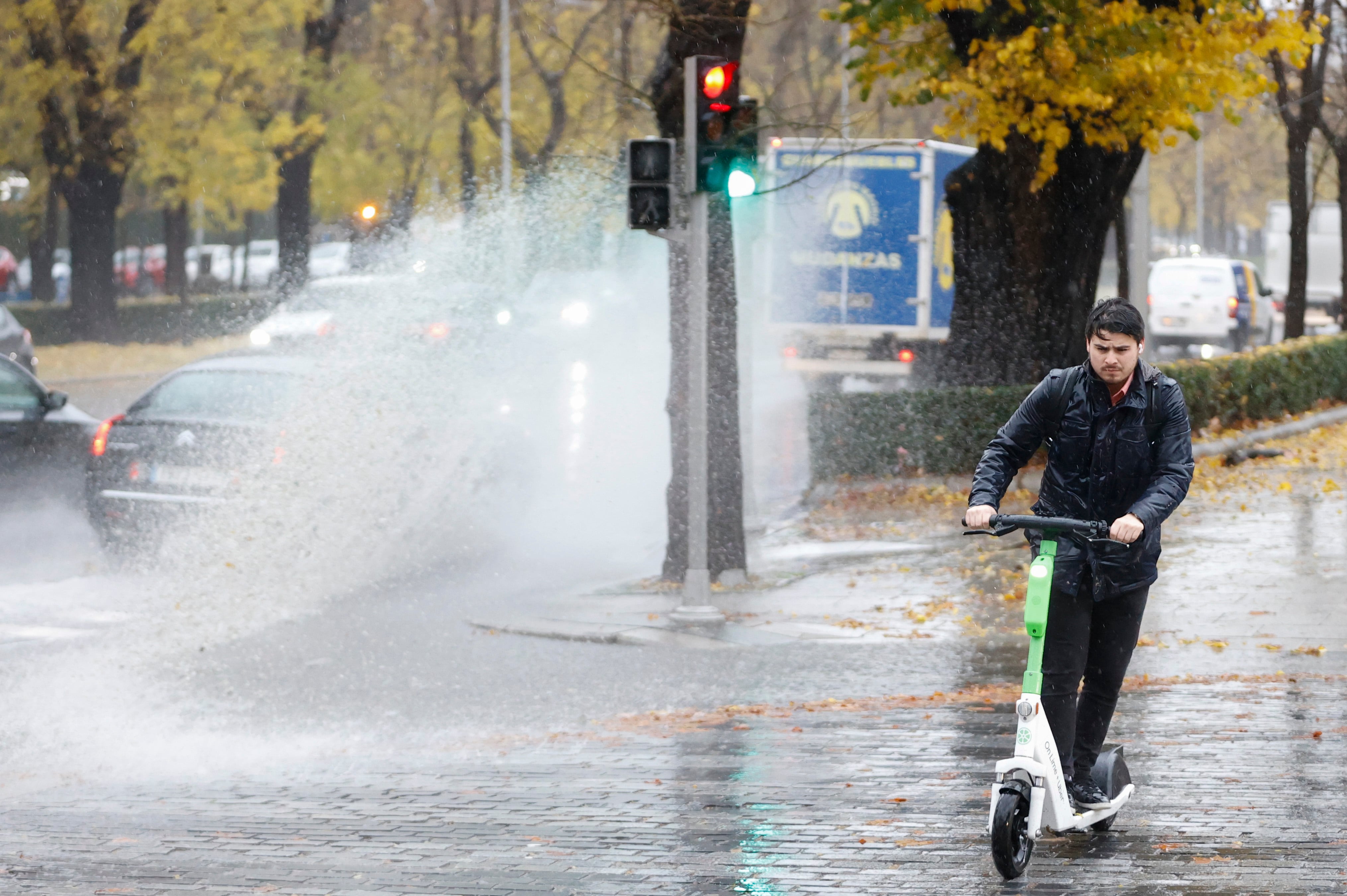 MADRID, 13/12/2022.- Un hombre usa un patinete eléctrico bajo la lluvia este martes en Madrid, que ha activado la fase de preemergencia del plan especial de Protección Civil ante inundaciones INUNCAM ante la previsión de lluvias abundantes. EFE/ Mariscal
