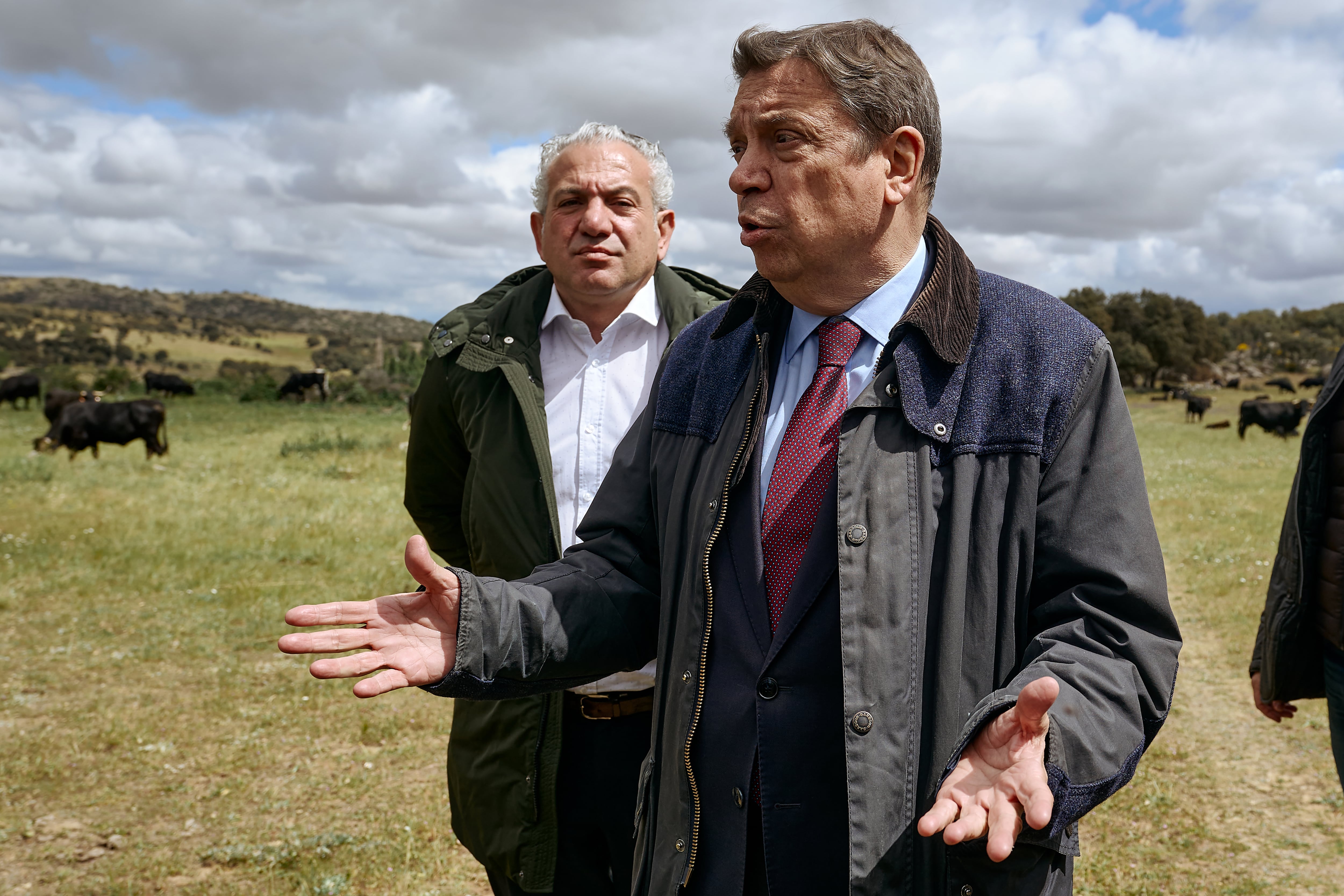 El ministro de Agricultura, Pesca y Alimentación, Luis Planas (d), durante su visita a las instalaciones de una ganadería en la localidad de Cardeñosa (Ávila)