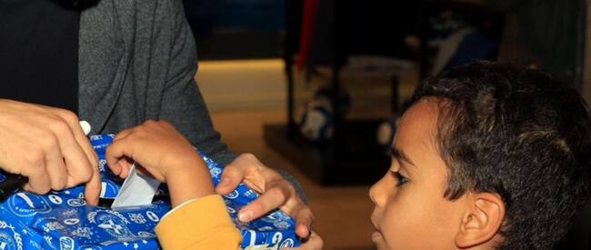 Un jugador del Deportivo entrega un regalo a un niño