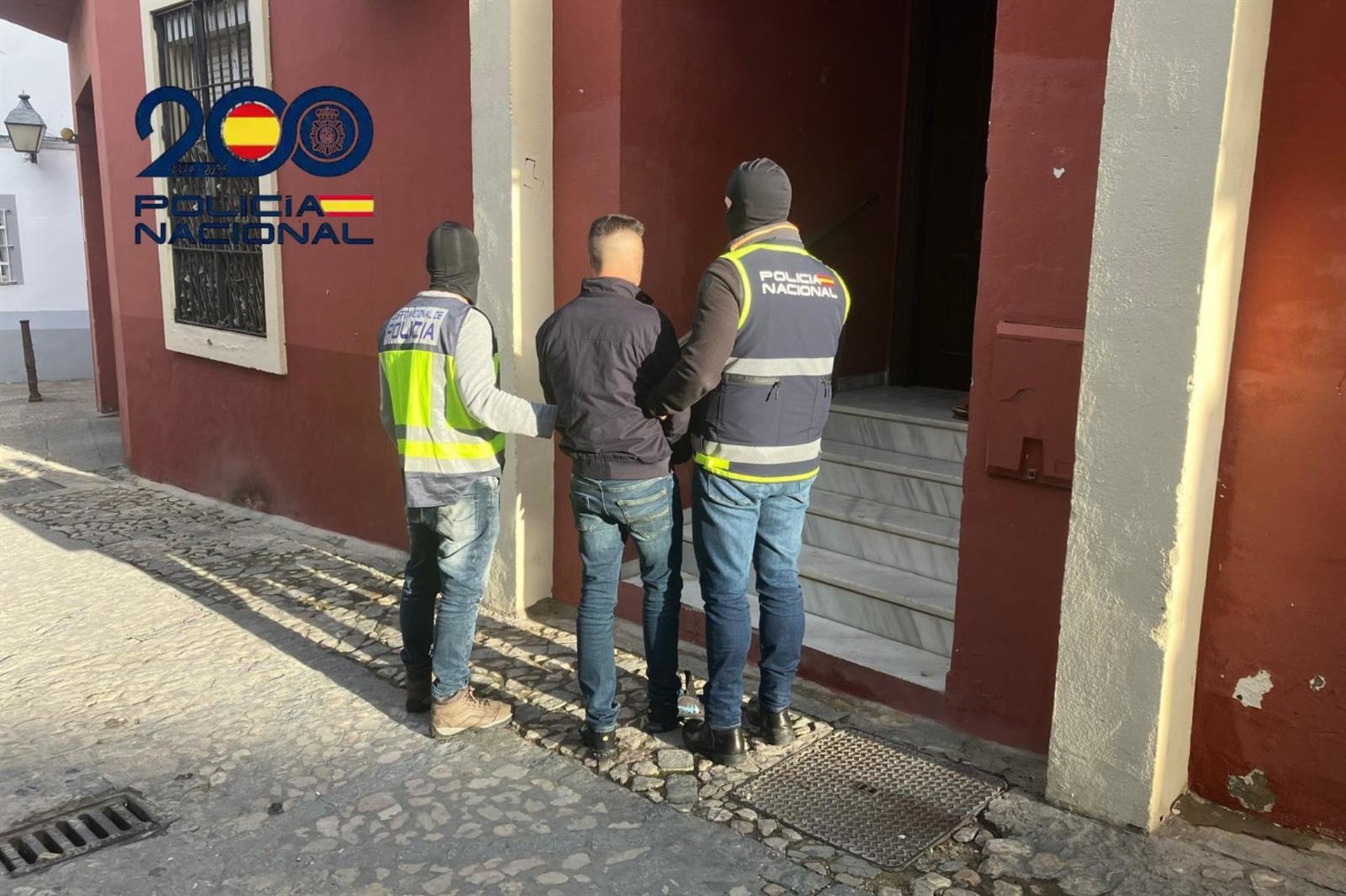 Dos agentes de la Policía Nacional escoltan a un detenido por la presunta muerte violenta de un vecino de Jerez de 77 años de edad con quien había mantenido una discusión