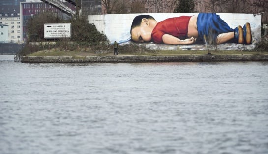 Vista general de un grafiti de Aylan Kurdi, el niño sirio que murió ahogado en las playas de Turquía y cuya fotografía se ha convertido en símbolo de la crisis de refugiados, en el puerto de Fráncfort (Alemania)