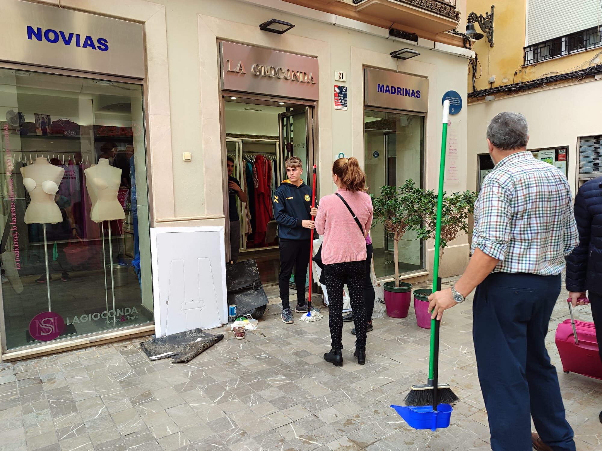 En calle Compañía los comerciantes limpian sus establecimientos tras el temporal.