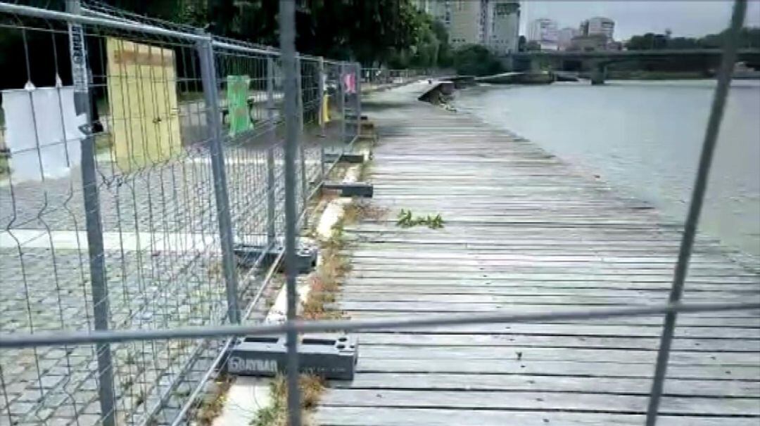 El paseo vallado con los carteles colgados criticando su abandono 