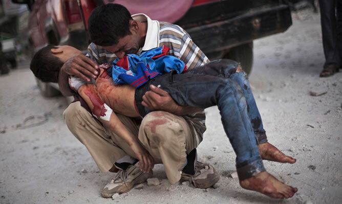 Un hombre sirio llora mientras sostiene el cadáver de su hijo en Alepo (Siria). El niño fue asesinado por el ejército sirio (MANU BRABO | Associated Press)