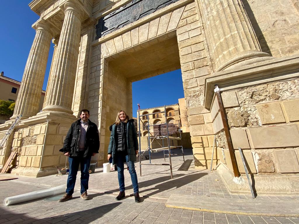 La restauradora Marina Ruiz y el constructor Antonio Rodríguez posan frente a la Puerta del Puente Romano de Córdoba