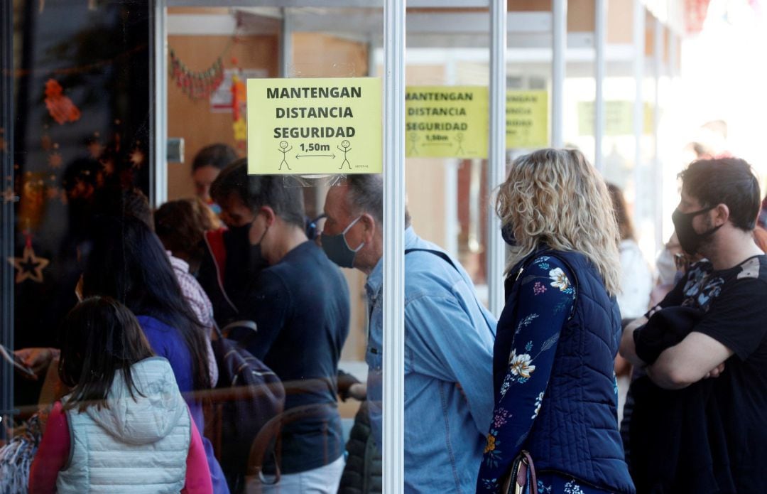 Varias personas aguardan su turno este domingo en un mercadillo debidamente señalizado con las medidas anti-covid a menos de dos semanas de celebrarse la navidad.