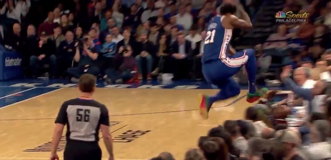 Embiid cae encima de un aficionado al intentar evitar que el balón salga fuera