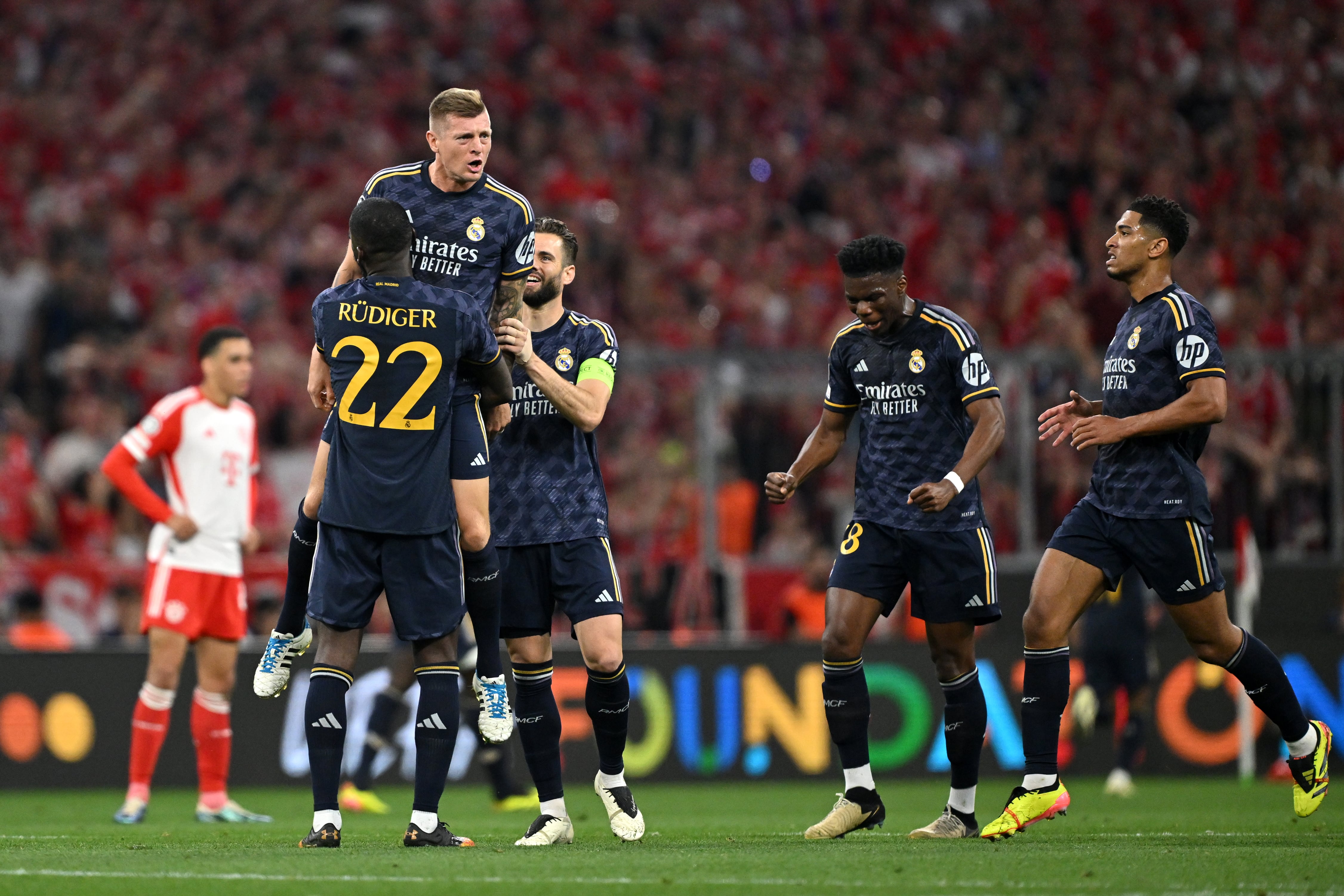 Los jugadores del Real Madrid se abrazan con Toni Kroos tras el 0-1 de Vinicius. (Sebastian Widmann - UEFA/UEFA via Getty Images)