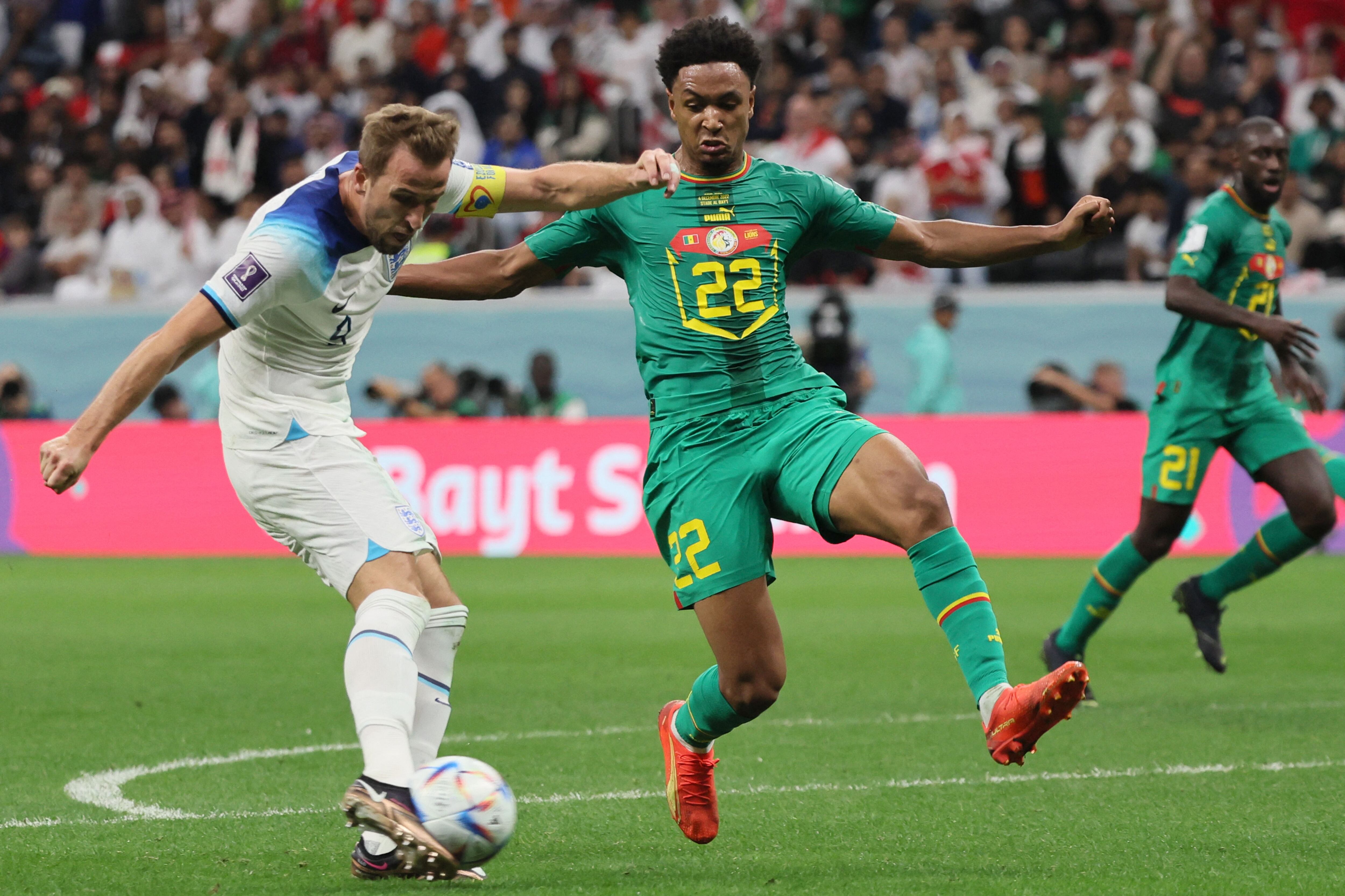 England&#039;s forward #09 Harry Kane strikes the ball next to Senegal&#039;s defender #22 Abdou Diallo to score his team&#039;s second goal during the Qatar 2022 World Cup round of 16 football match between England and Senegal at the Al-Bayt Stadium in Al Khor, north of Doha on December 4, 2022. (Photo by JACK GUEZ / AFP) (Photo by JACK GUEZ/AFP via Getty Images)