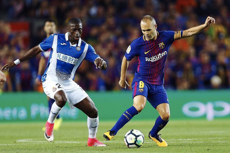 El centrocampista del FC Barcelona Andrés Iniesta pelea un balón con el jugador senegalés del Espanyol Pape Diop