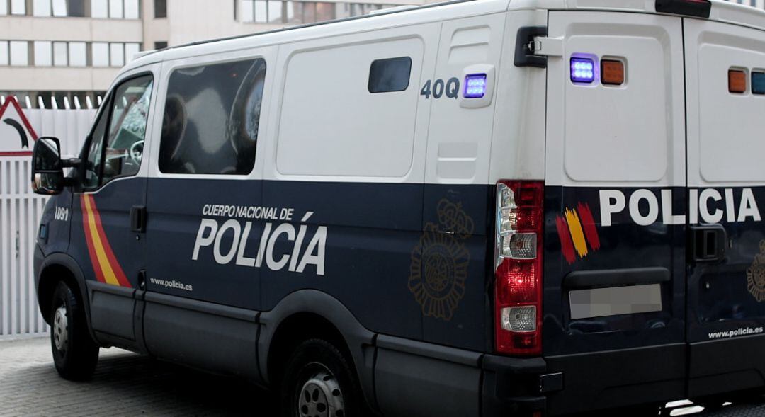 Un furgón de la Policía Nacional entra por una puerta de unos juzgados.