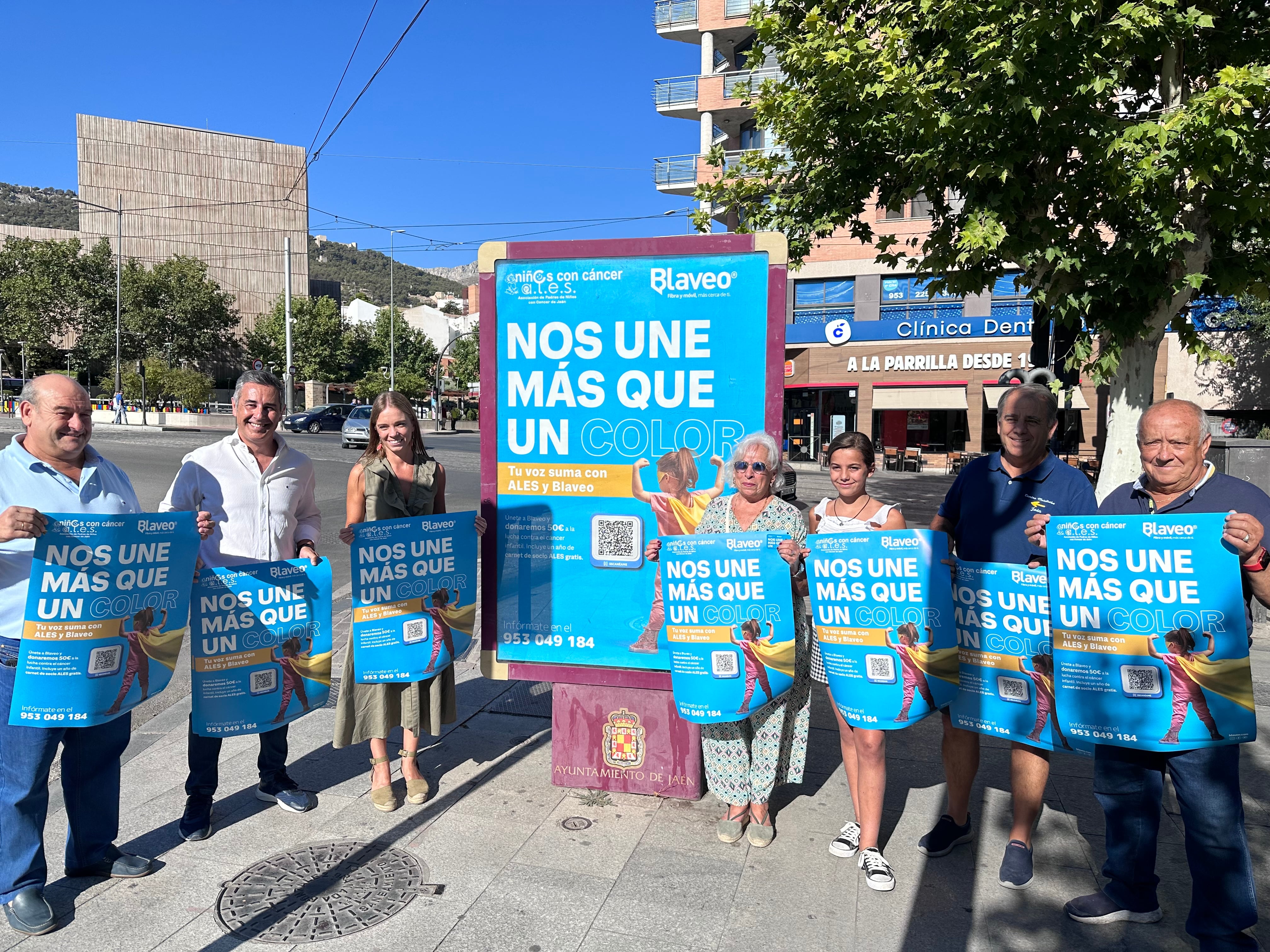 Responsables y miembros de ALES, Blaveo e InnovaSur posan junto al cartel de su nueva campaña de ayuda.