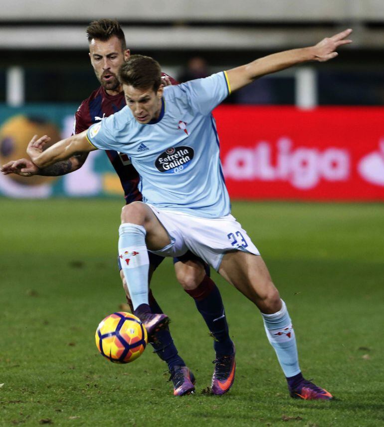 El defensa del Eibar Antonio Luna (i) disputa un balón con el centrocampista del Celta de Vigo Josep Señé (d), durante el partido de la duodécima jornada de la Liga de Primera División jugado en el estadio de Ipurúa de Eibar.
