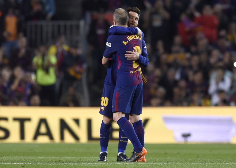 Andrés Iniesta y Leo Messi se abrazan durante el encuentro entre el FC Barcelona y el Real Madrid.