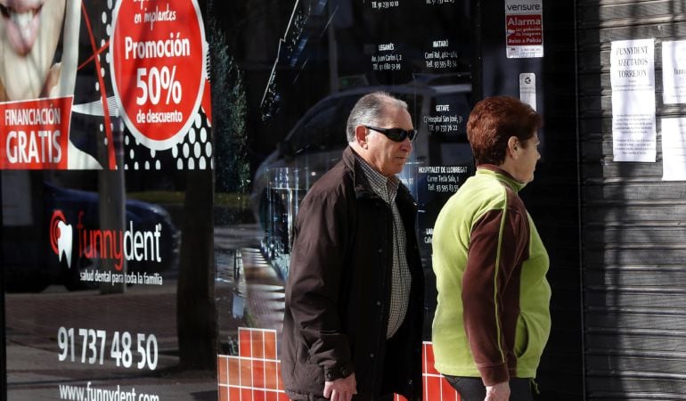 Dos personas leen los avisos dejados en la clínica Funnydent de Torrejón de Ardoz para los afectados por el cierre inesperado de los nueve centros que dispone en España la cadena